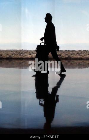 25.02.2023, Qatar, , Doha - Silhouette: Viaggiatore nel terminale dell'Aeroporto Internazionale di Hamad. 00S230225D399CAROEX.JPG [VERSIONE DEL MODELLO: SÌ, PROOTT Foto Stock