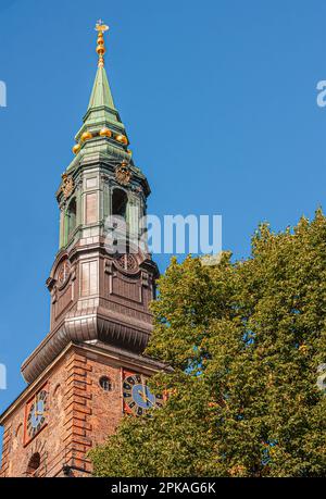 Copenaghen, Danimarca - 13 settembre 2010: Sankt Petri Kirke, chiesa, contro il cielo blu. Ornamenti dorati e orologio, verde fogliame in angolo Foto Stock