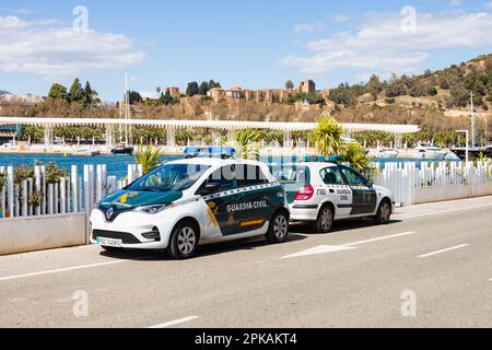 Guardia Civil, Border and Customs Police auto parcheggiate sul Paseo de la Farola, Malaga, Andalusia, Costa del Sol. Renault Zoe elettrica, verde, Spagna. Foto Stock