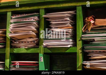 Scaffali verdi con pila di lettere Foto Stock