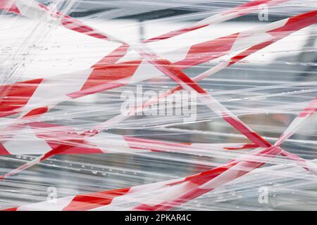 Nastro barriera rosso e bianco e foglio di plastica trasparente come barriera Foto Stock