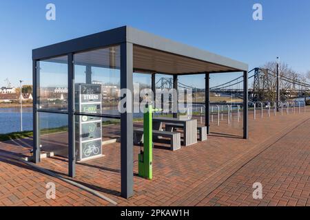 Stazione di ricarica e-bike con piccola stazione di riparazione, area di sosta biciclette sulla spiaggia sud, Wilhelmshaven, bassa Sassonia, Germania Foto Stock