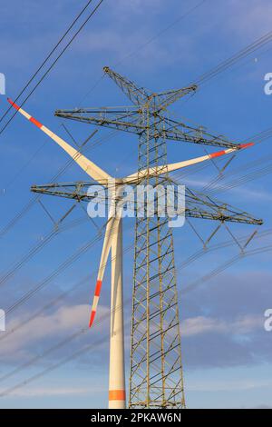 Linea elettrica aerea, nella turbina eolica di fondo sul canale EMS-Jade, di Friesen-Elektra II GmbH & Co KG, a Sande, comune nel distretto di Friesland, bassa Sassonia, Germania Foto Stock