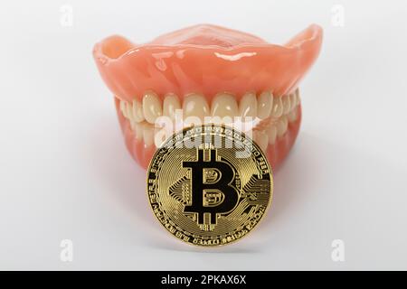 Dentiera con una moneta bitcoin, immagine simbolo, metodo di pagamento, moneta digitale, criptovaluta, sfondo bianco, Foto Stock