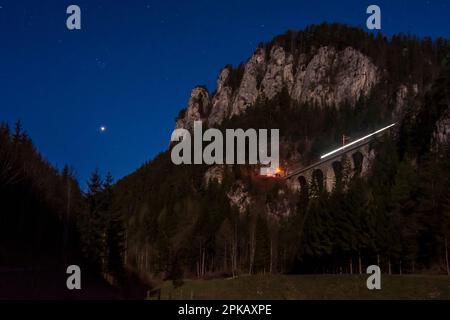 Breitenstein: Semmeringbahn (Ferrovia di Semmering), viadotto Krausel-Klause-Viadukt, Polleroswand roccia faccia, stelle, pianeta venere, leggero sentiero del treno in Foto Stock