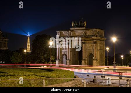 Arco trionfale in Piazza Caroussel di fronte al Palazzo del Louvre, vista della Torre Eiffel illuminata sul retro, Parigi, Francia Foto Stock