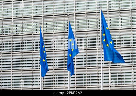 Quartiere europeo di Bruxelles, Belgio - 15 marzo 2023 - tre bandiere europee con l'edificio Berlaymont sullo sfondo Foto Stock