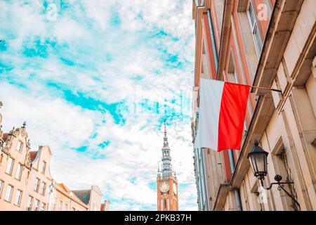 Polonia bandiera in cielo blu e il centro di Danzica sullo sfondo Foto Stock