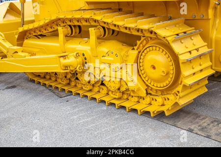 Cingoli metallici continui del bulldozer, giallo caterpillar. Foto Stock