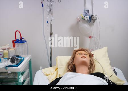 Gli studenti che devono affrontare un'emergenza post-natale seguono le procedure su un manichino. Questo manichino è controllato dagli operatori in una stanza adiacente. Foto Stock