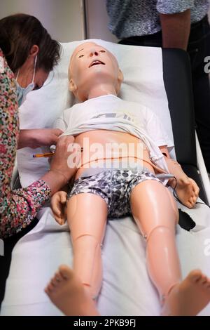I medici generici sono addestrati alle procedure di emergenza pediatrica. Preparazione del fantoccio per la simulazione di emergenza. Foto Stock