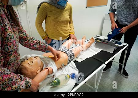 I medici generici sono addestrati alle procedure di emergenza pediatrica. Preparazione del fantoccio per la simulazione di emergenza. Foto Stock