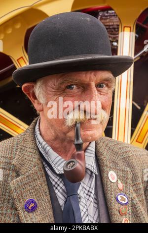 Inghilterra, Dorset, la fiera annuale del vapore del grande Dorset a Tarrant Hinton vicino Blandford Forum, Ritratto di Gentleman vestito in Bowler Hat Smoking Pipe Foto Stock