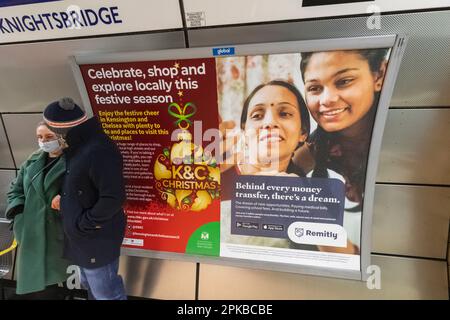 Inghilterra, Londra, coppia in piedi di fronte al Poster alla stazione della metropolitana di Knightsbridge Foto Stock