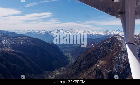 Vista aerea da un aereo leggero di una valle con montagne innevate nelle alpi, Valle d'Aosta, NW Italia Foto Stock