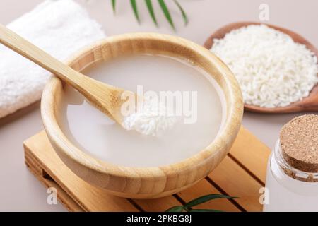 Acqua di riso cosmetica fatta in casa con ingredienti su sfondo beige, sani trattamenti di bellezza ingredienti per la competica fatta in casa, ricetta di bellezza per la casa Foto Stock