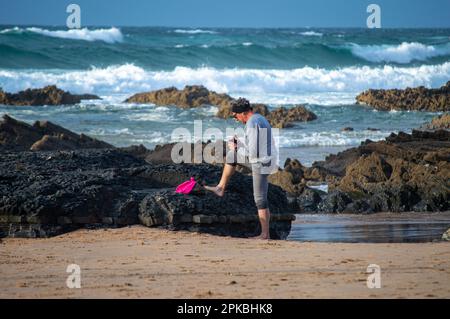 SAGRES, PORTOGALLO - 27 FEBBRAIO 2023: Uomo che cammina sulla spiaggia Praia do Castelejo vicino Sagres Sagres, Portogallo il 27 febbraio 2023 Foto Stock