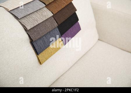 Catalogo di tessuti colorati su divani beige Foto Stock