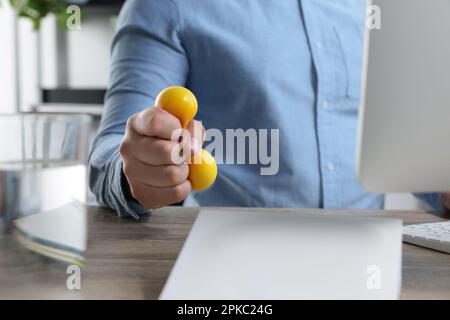 Uomo schiacciare palla antistress mentre lavora con il computer in ufficio,  primo piano Foto stock - Alamy