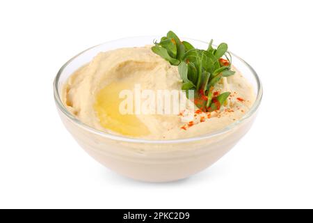 Ciotola di gustoso hummus con foglie di piselli e paprika isolato su bianco Foto Stock