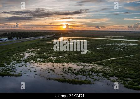 Immagine aerea dell'orizzonte con un tramonto sopra la verde palude in Florida Foto Stock