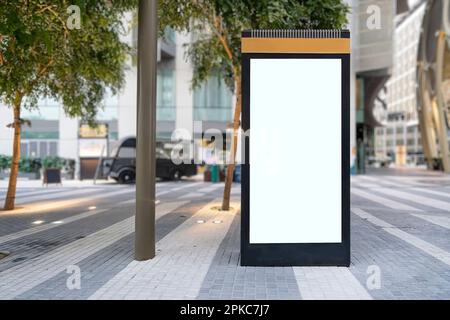 Mock up bianco di cartellone verticale del cartellone stradale sullo sfondo della città. Tabellone elettronico vuoto moderno sullo sfondo di una strada cittadina. copia spac Foto Stock