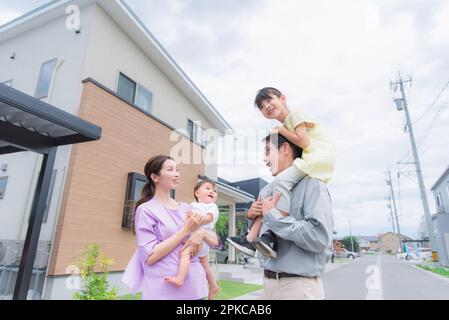 Il bambino è trasportato dalla madre e dalla ragazza che è trasportato sulle spalle del padre Foto Stock