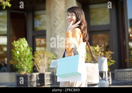 Donna sorridente che ama fare shopping Foto Stock