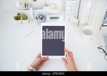 Donna con un tablet su un tavolo bianco Foto Stock