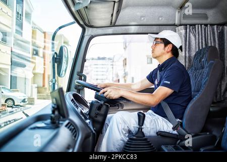 Uomo che guida un camion di grandi dimensioni Foto Stock