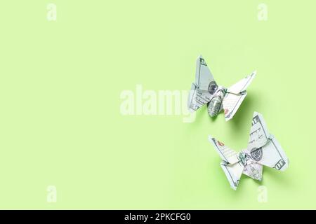 Farfalle Origami fatte di banconote in dollari su sfondo verde Foto Stock