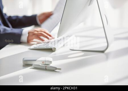 Un uomo alla sua scrivania che fuma un ICO Foto Stock