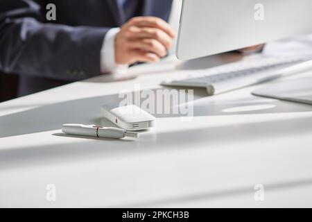 Gli ICO si trovano accanto a un uomo che lavora alla scrivania Foto Stock