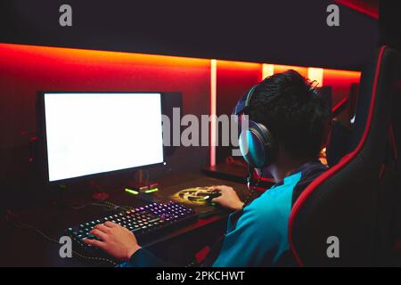 Un giocatore maschio che gioca una partita in un caffè eSports Foto Stock