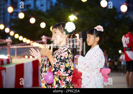 Ragazza in yukata danza bon danza in un festival Foto Stock