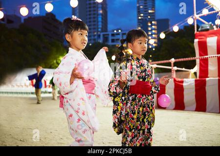 Ragazza in yukata danza bon danza in un festival Foto Stock