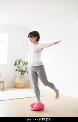 Donna che lavora all'interno con disco di bilanciamento Foto Stock