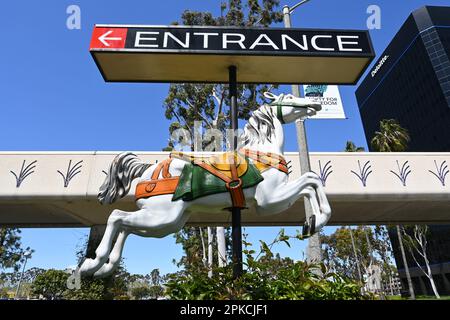 COSTA MESA, CALIFORNIA: 4 Apr 2023: Carousel Horse segna l'ingresso di Bristol Street a South Coast Plaza con il Ponte Unity sullo sfondo. Foto Stock