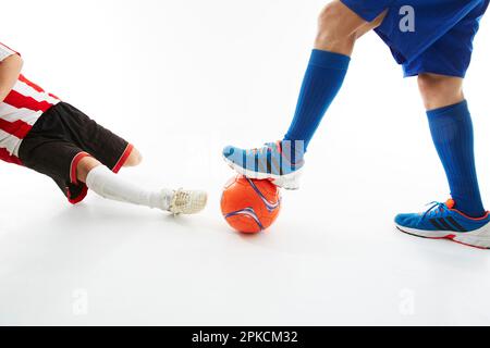 Giocatore di calcio che scivola per tagliare la palla dell'avversario Foto Stock