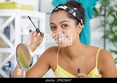 una donna felice e make-up master corregge Foto Stock