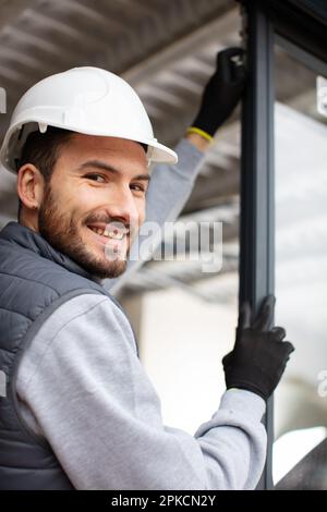 operaio installa finestre e porte in una proprietà Foto Stock