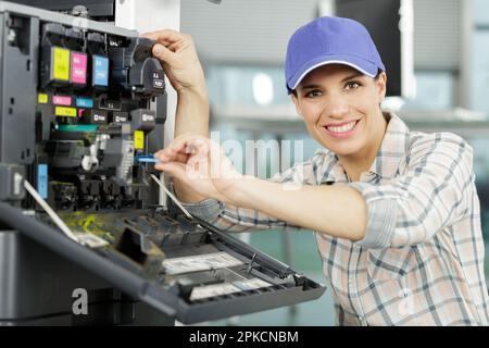 felice donna che ripara una stampante Foto Stock