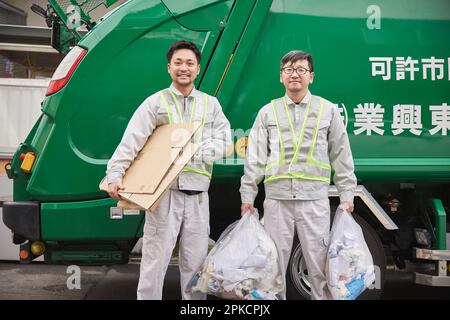 Lavoratore maschio con un camion imballatore e spazzatura Foto Stock