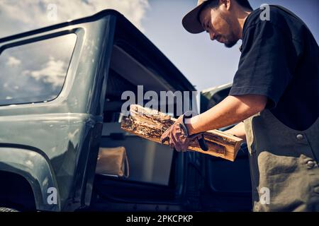 Uomo che prende legna da ardere fuori dall'auto Foto Stock