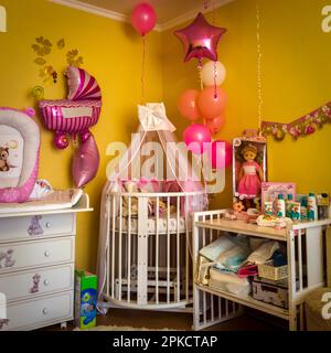 Il letto della bambina nell'angolo della camera è decorato con palloncini. Foto Stock