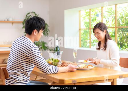 Una coppia in 30s che beve champagne e pranza il giorno libero Foto Stock