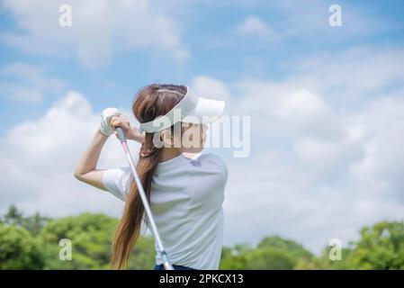 Le donne nei loro 20s che giocano il golf Foto Stock