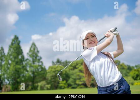 Le donne nei loro 20s che giocano il golf Foto Stock
