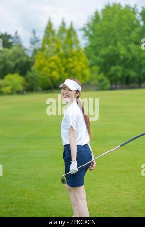 Le donne nei loro 20s che giocano il golf Foto Stock