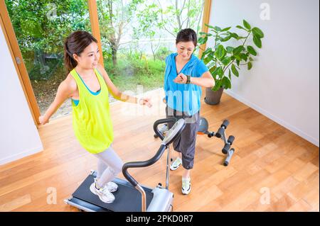 Madre e figlia che si allenano con la macchina a casa propria Foto Stock